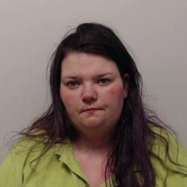 Image of Julie Ann McQuade - larger woman with round face and long dark hair wearing lime green shirt