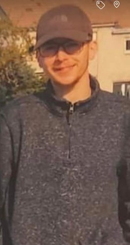 Shows Blane Rundell, 22, white male earing a grey cap, glasses and a grey top