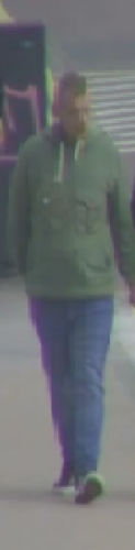 A CCTV image of a man wearing a green jacket and blue jeans