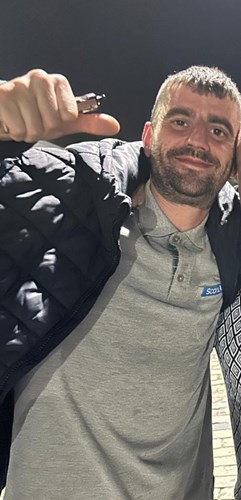 Scott McFadden, a white man with short brown hair, a short beard, a grey polo shirt and a dark jacket