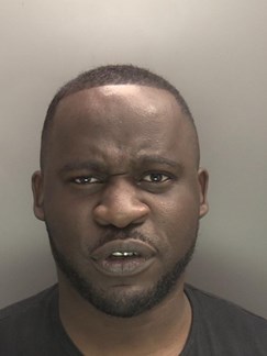 Image of man sentenced Fleury Tsaty - black man with frowning expression, short dark hair and beard wearing black tshirt