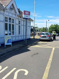 Image outside Troon train station of Project Servator police officers speaking to the driver of a silver car about their deployment