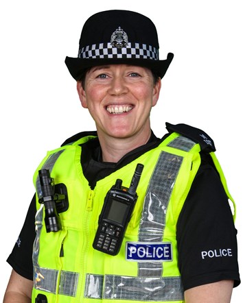 PC Stephanie Rose in full police uniform smiling in front of a white background. PC Rose is wearing a black police hat and shirt, with hi-vis body armour with police equipment attached to it.